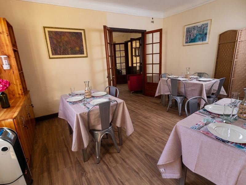 Comedor visto desde el acceso, con mesas servidas.