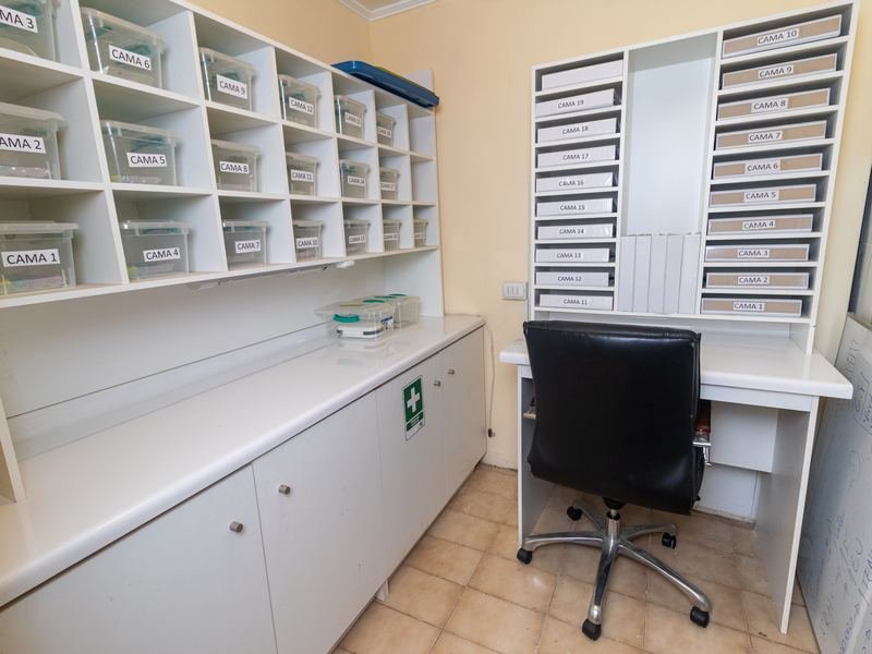 Sala de enfermería con casilleros y escritorio de trabajo.