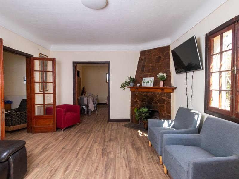 Sala de estar amplia, con sillones y chimenea al fondo.