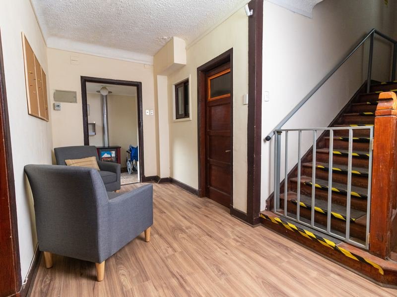 Hall con escalera y sillón de espera.