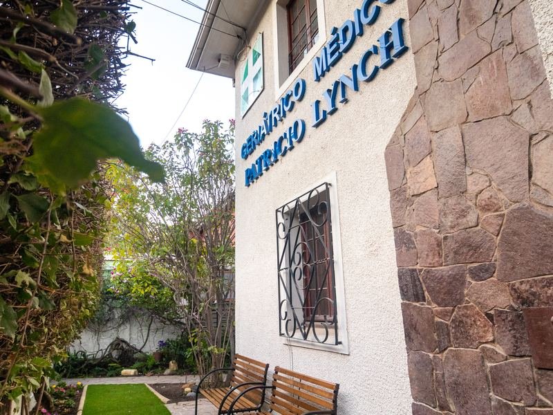 Fachada con revestimiento de piedra y el letrero de la residencia.