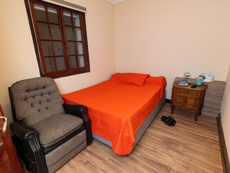 Habitación individual con cama y sillón reclinable.