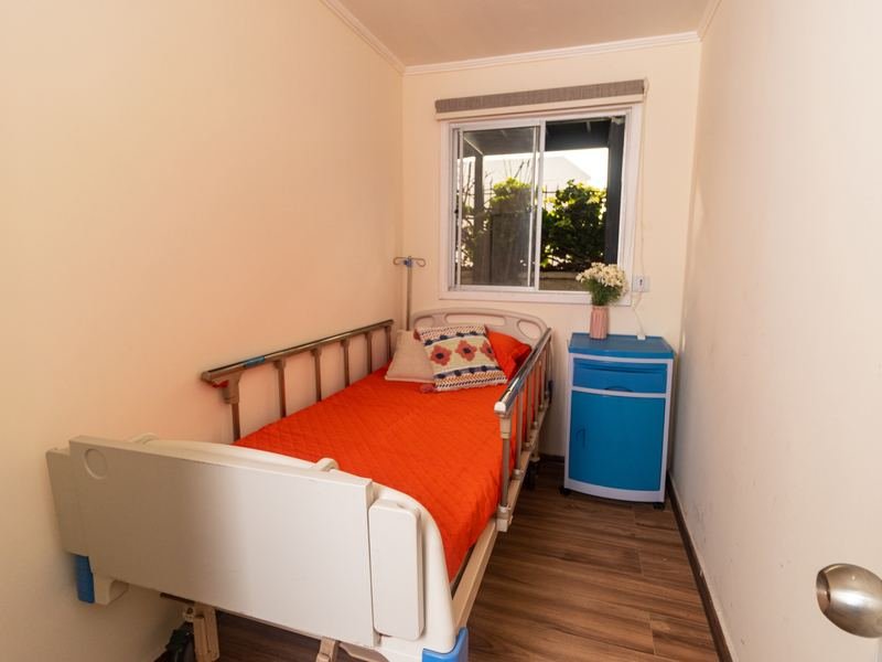 Habitación individual con la cama junto a la ventana.